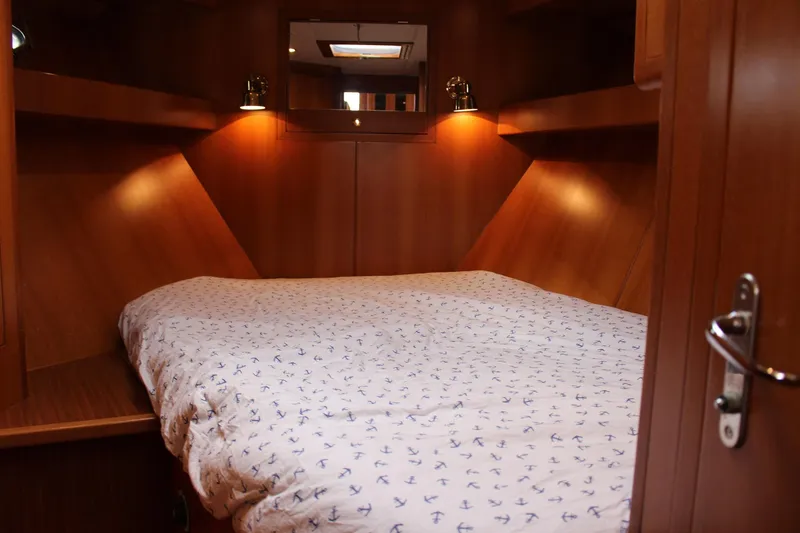 Slide: The Image of Cozy bedroom interior of 2007 Jefferson 45 Motor Yacht with wood paneling and anchor-patterned bedding. - 16