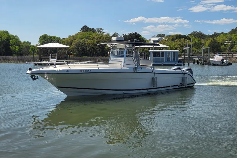 The Image of Century 3100 Center Console boat from 2000 on a calm river, surrounded by greenery. - 0