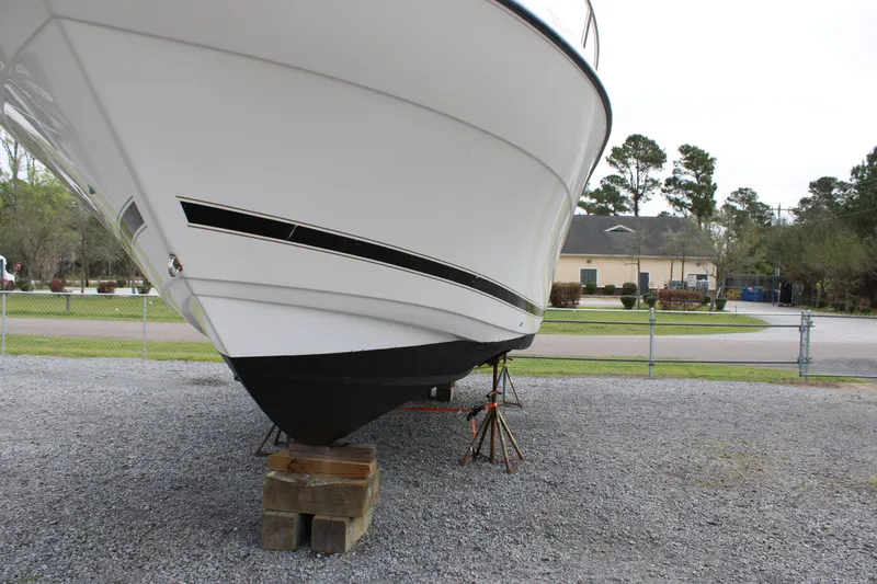 Slide: The Image of Century 3100 boat from 2000 on stands, displayed outdoors. - 11