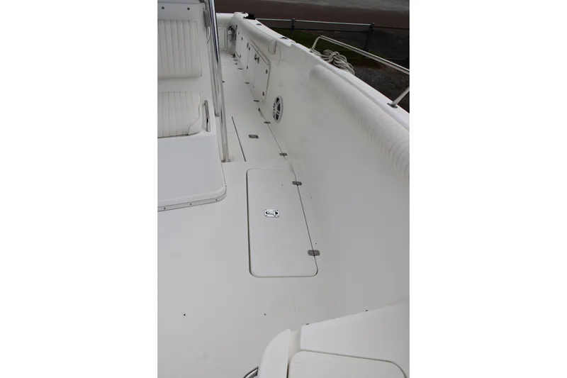 Slide: The Image of White deck of a 2000 Century 3100 boat with seating and storage compartments. - 16