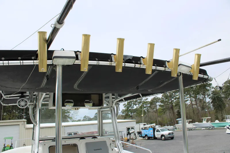 Slide: The Image of Century 3100 boat with rod holders and canopy, parked outdoors, year 2000 model. - 29