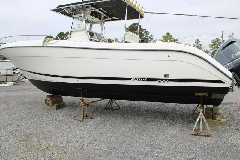 Slide: The Image of Century 3100 boat from 2000 on stands, white hull, outdoor setting. - 3