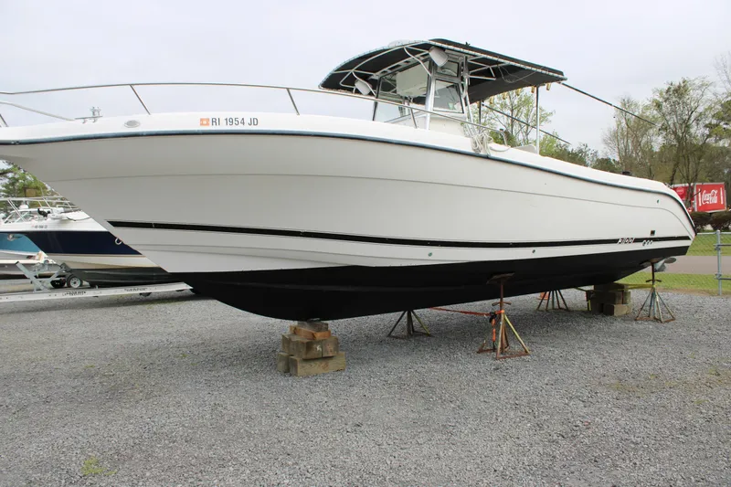 Slide: The Image of Century 3100 boat from 2000 on stands, displayed outdoors on gravel. - 4