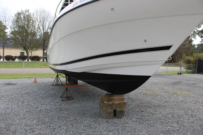 Slide: The Image of Century 3100 boat from 2000 on stands, gravel lot, side view. - 5