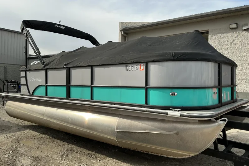 Slide: The Image of 2024 Bentley Pontoons 200 Navigator with black cover, parked outdoors. - 13