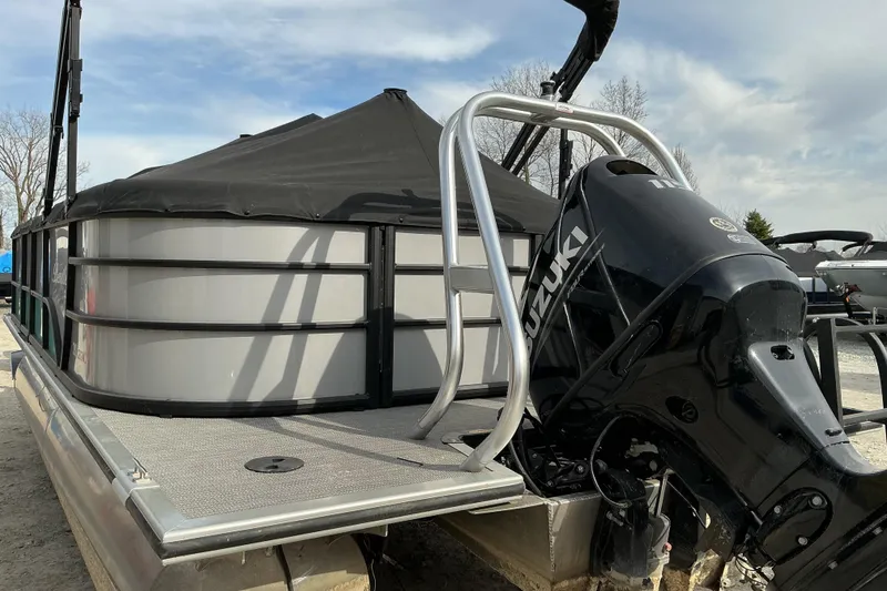 Slide: The Image of 2024 Bentley Pontoons 200 Navigator with Suzuki outboard motor, docked under a cloudy sky. - 14