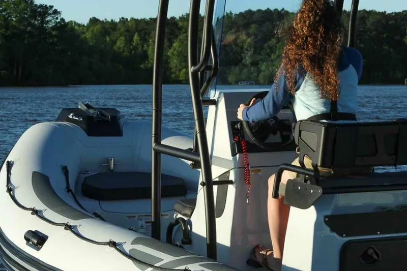 Slide: The Image of Manufacturer Provided Image: Woman steering Zodiac Pro 6.5 boat on a lake, 2026 model. - 3