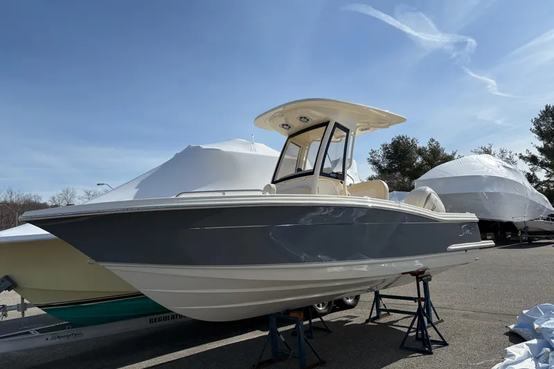 The Image of 2026 Scout 220 XSF boat on stands, under clear blue sky. - 0