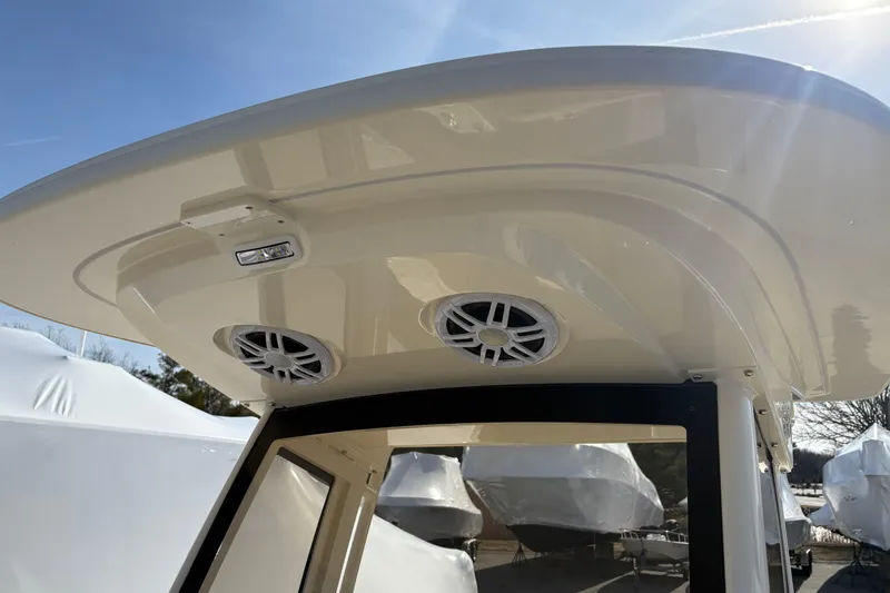 Slide: The Image of 2026 Scout 220 XSF boat roof with speakers and light under clear sky. - 12