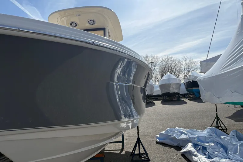 Slide: The Image of 2026 Scout 220 XSF boat in storage, partially covered, under a clear sky. - 3