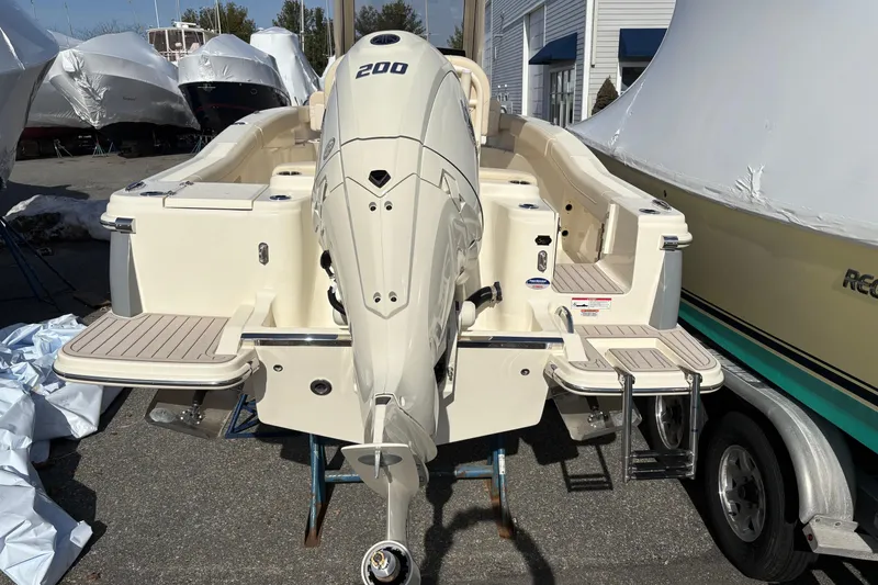 Slide: The Image of 2026 Scout 220 XSF boat with powerful outboard motor, docked outdoors. - 4