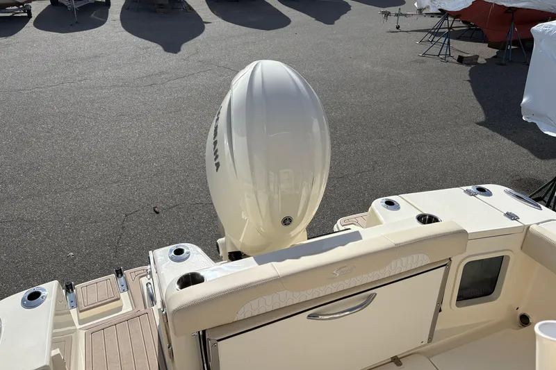 Slide: The Image of 2026 Scout 220 XSF boat with outboard motor in a parking area. - 5