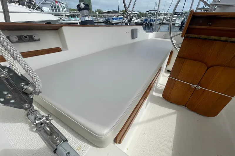 Slide: The Image of Cockpit of 1987 Com-Pac 27 sailboat with cushioned seating and wooden details. - 10