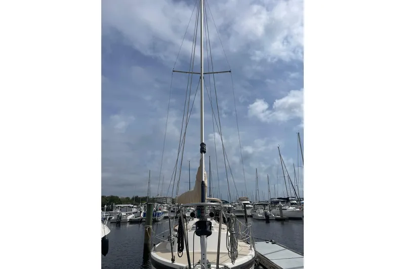 Slide: The Image of Sailboat docked at marina, Com-Pac 27, 1987 model, under cloudy sky. - 12
