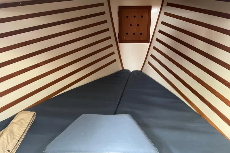 Slide: The Image of Interior cabin of a 1987 Com-Pac 27 sailboat with wooden accents and cushions. - 22
