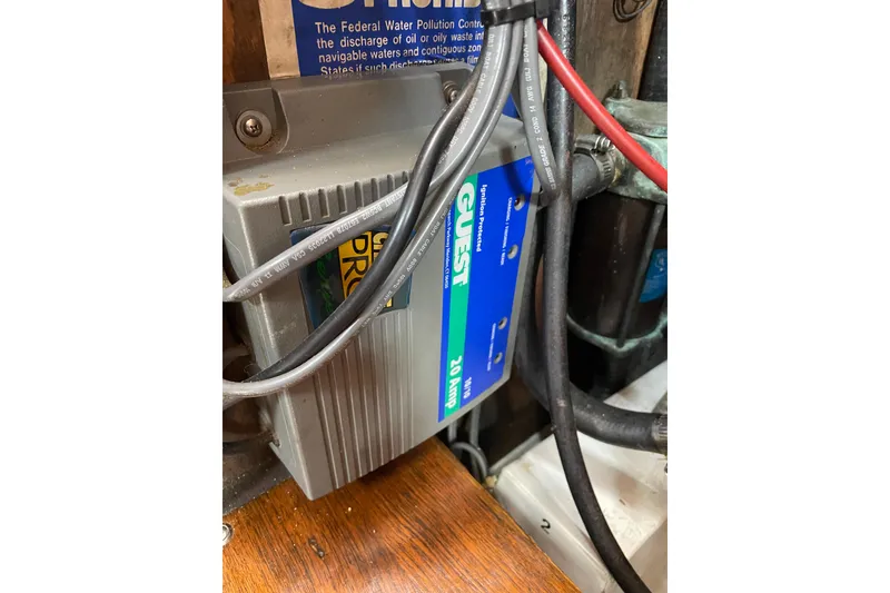 Slide: The Image of Electrical system inside a 1987 Com-Pac 27 boat, featuring a Guest battery charger. - 26