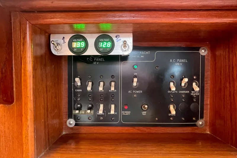 Slide: The Image of Electrical panel of a 1987 Com-Pac 27 yacht with voltage meters and switches. - 28
