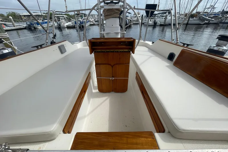 Slide: The Image of Cockpit of 1987 Com-Pac 27 sailboat with wooden accents and marina view. - 9