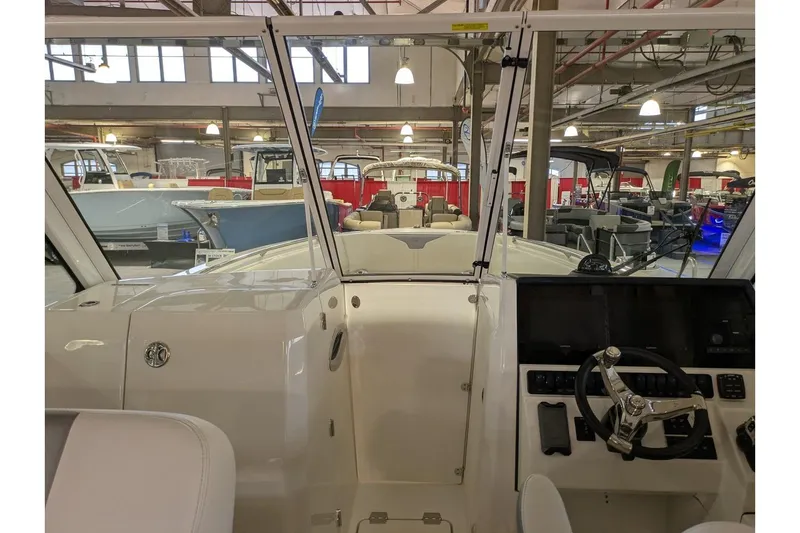 Slide: The Image of 2025 Sailfish 276 DC boat interior with steering wheel and dashboard in showroom. - 12