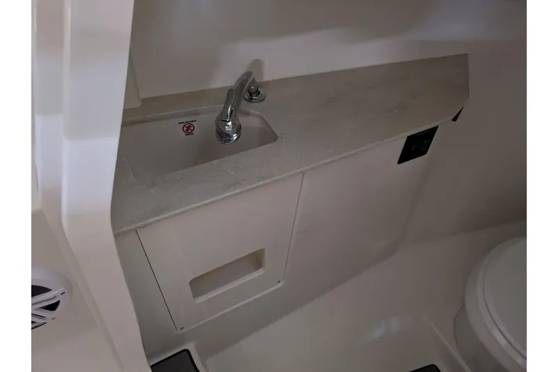 Slide: The Image of 2025 Sailfish 276 DC boat interior with sink and faucet in compact bathroom. - 13