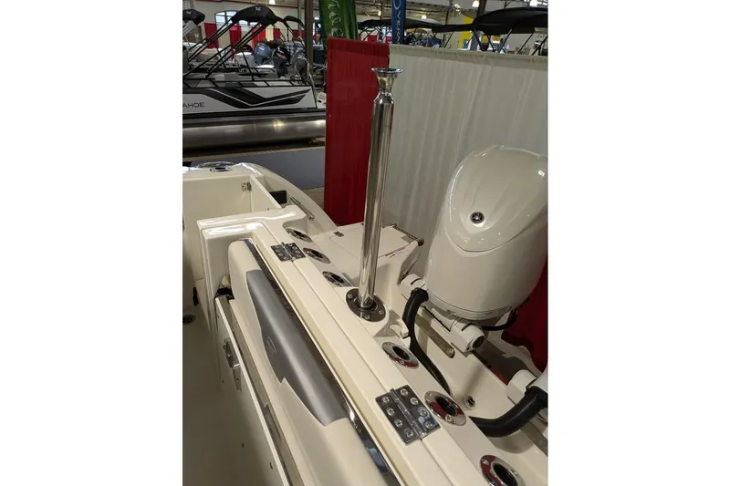Slide: The Image of 2025 Sailfish 276 DC boat interior with motor and rod holders at a boat show. - 22