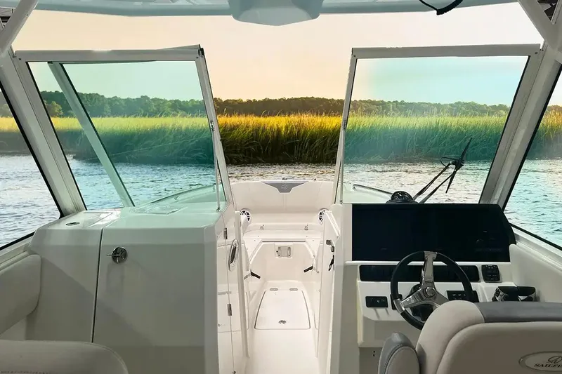 Slide: The Image of Manufacturer Provided Image: 2025 Sailfish 276 DC boat interior with steering wheel, dashboard, and scenic water view. - 28