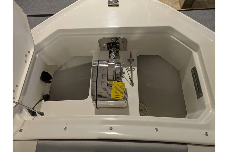 Slide: The Image of Anchor compartment of 2025 Sailfish 276 DC boat, featuring a winch and storage space. - 9