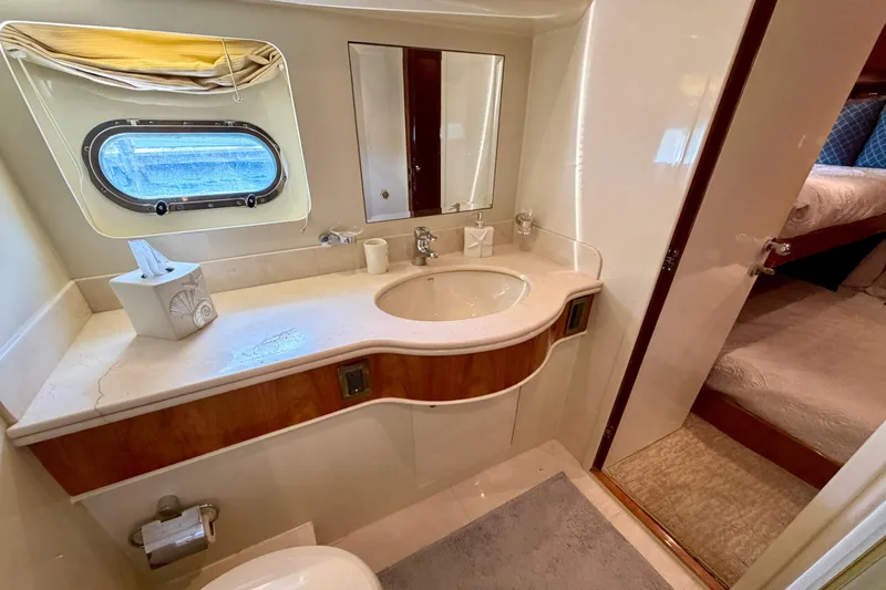 Slide: The Image of Luxurious bathroom on Horizon 92 yacht with sink, mirror, and porthole window. - 104