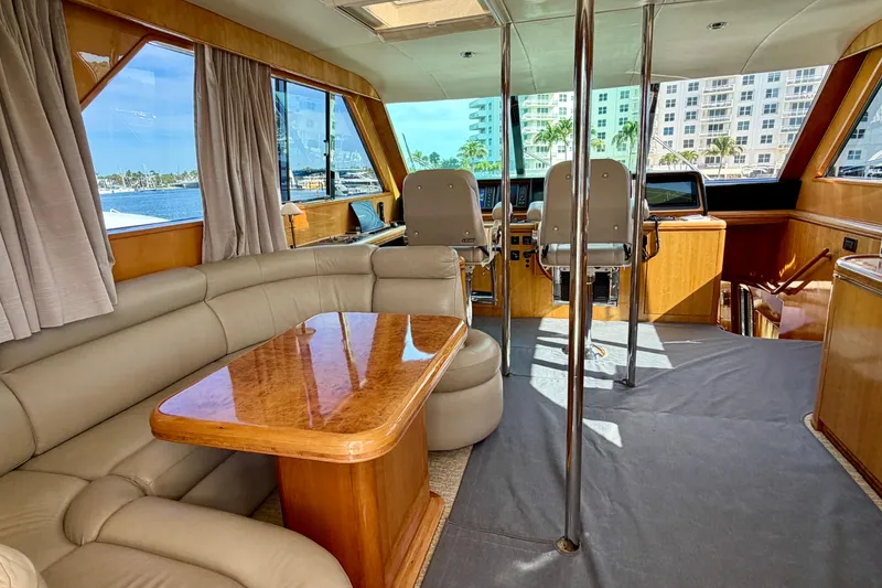 Slide: The Image of Luxurious Horizon 92 yacht interior with leather seating, wooden table, and helm station. - 115