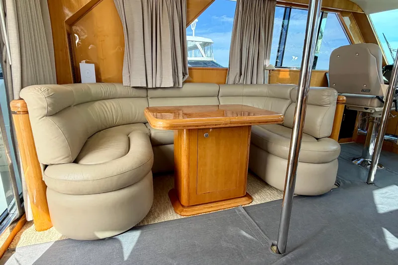 Slide: The Image of Luxurious Horizon 92 yacht interior with beige leather seating and wooden table. - 116