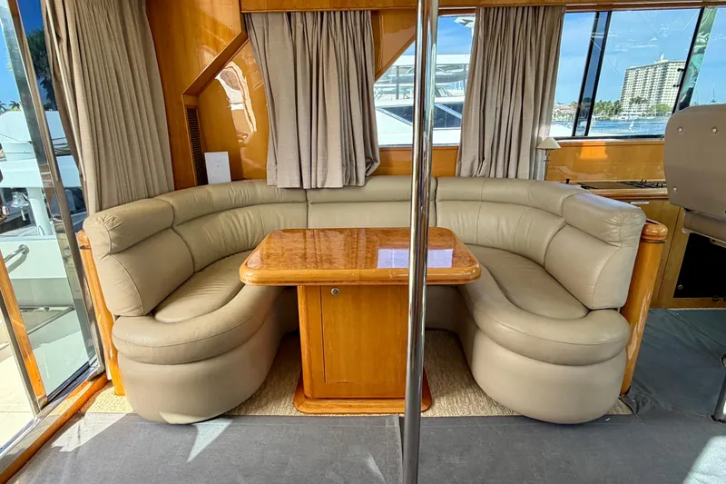 Slide: The Image of Luxurious Horizon 92 yacht interior with curved leather seating and wooden table. - 117
