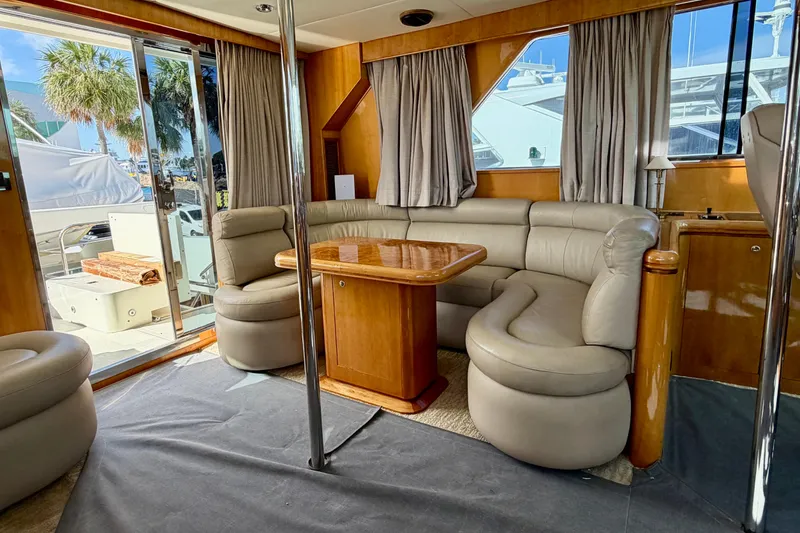Slide: The Image of Luxurious Horizon 92 yacht interior with leather seating and wooden table, featuring large windows. - 120