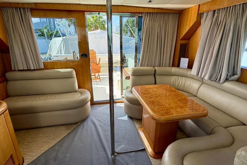 Slide: The Image of Luxurious yacht interior with beige leather seating, wooden table, and large windows. Horizon 92 model. - 121