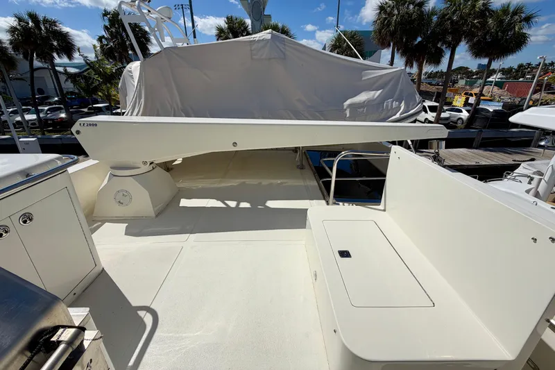 Slide: The Image of Deck of Horizon 92 yacht with seating and covered equipment, surrounded by palm trees. - 127