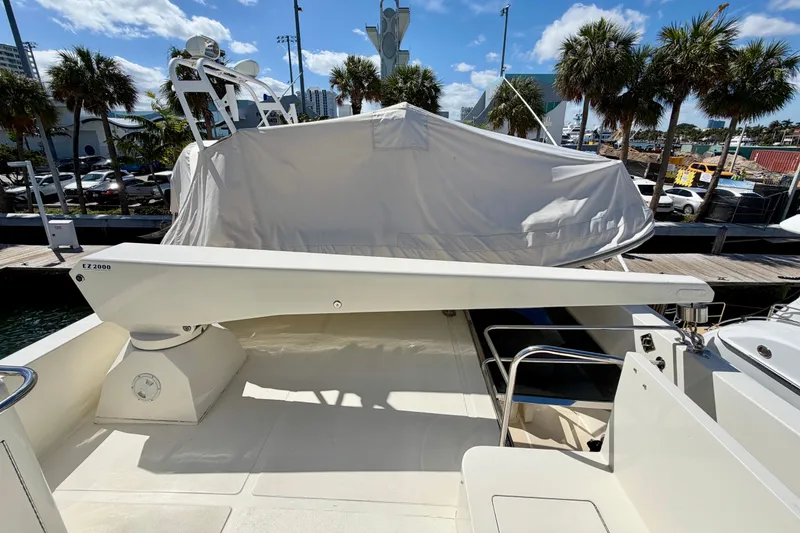 Slide: The Image of Luxury Horizon 92 yacht deck with covered equipment, palm trees, and marina backdrop. - 128