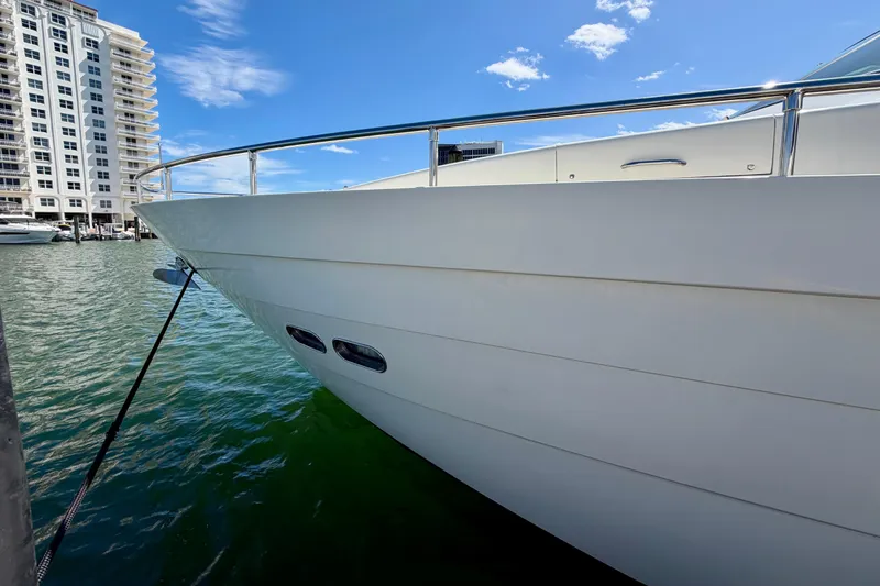 Slide: The Image of Luxury Horizon 92 yacht docked near waterfront building under clear blue sky. - 145