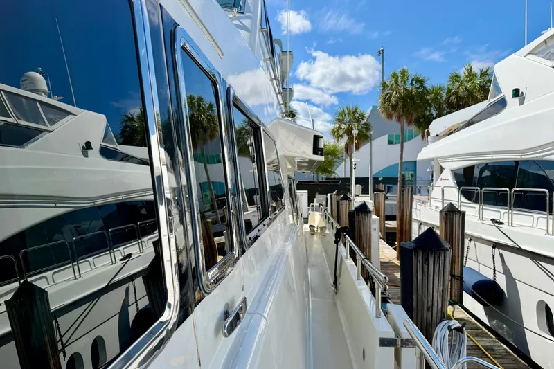 Slide: The Image of Luxury Horizon 92 yacht docked at marina with palm trees and blue sky. - 25
