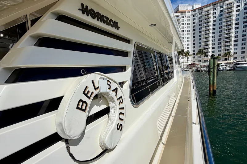 Slide: The Image of Luxury Horizon 92 yacht docked at marina with cityscape in background. - 34