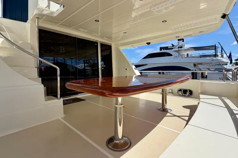 Slide: The Image of Luxurious Horizon 92 yacht deck with polished wooden table and marina view. - 38