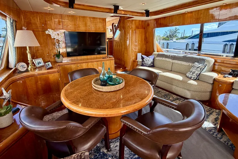 Slide: The Image of Luxurious yacht interior with wooden decor, round table, leather chairs, and large windows. Horizon 92 model. - 48