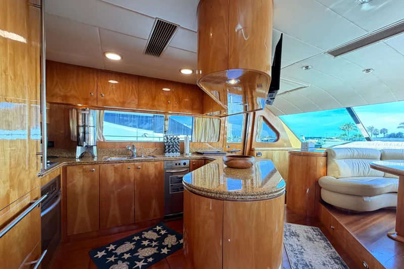 Slide: The Image of Luxurious Horizon 92 yacht kitchen with wood cabinetry, granite countertops, and ocean view. - 54