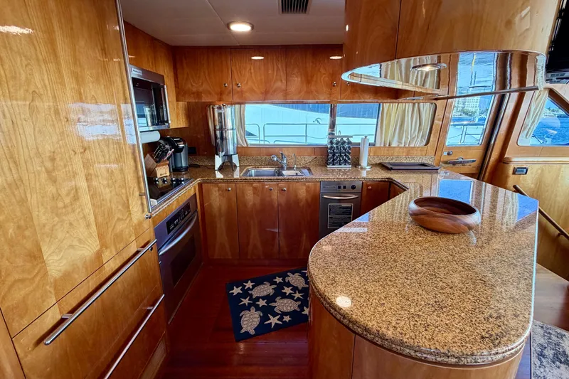 Slide: The Image of Luxurious yacht kitchen with wooden cabinetry and granite countertops on Horizon 92 model. - 55