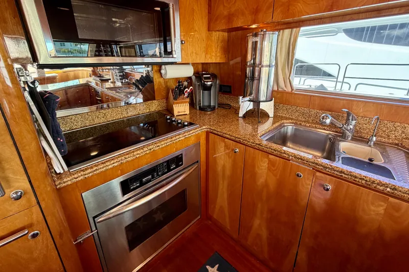 Slide: The Image of Luxurious yacht kitchen with granite countertops, stainless steel appliances, and wooden cabinetry on Horizon 92. - 56