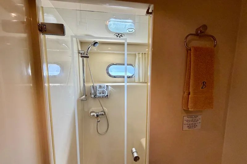 Slide: The Image of Shower area in Horizon 92 yacht with towel and porthole window. - 76
