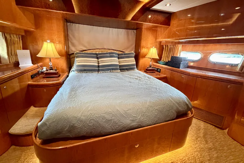 Slide: The Image of Luxurious Horizon 92 yacht bedroom with elegant wood paneling and ambient lighting. - 84