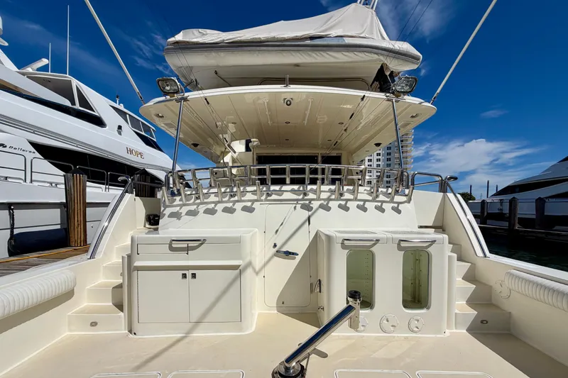 Slide: The Image of Luxury Horizon 92 yacht docked, showcasing spacious deck and modern amenities under clear blue sky. - 9