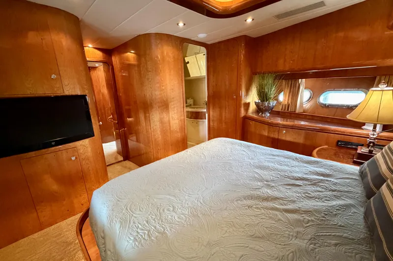 Slide: The Image of Luxurious Horizon 92 yacht bedroom with wood paneling, TV, and elegant decor. - 95
