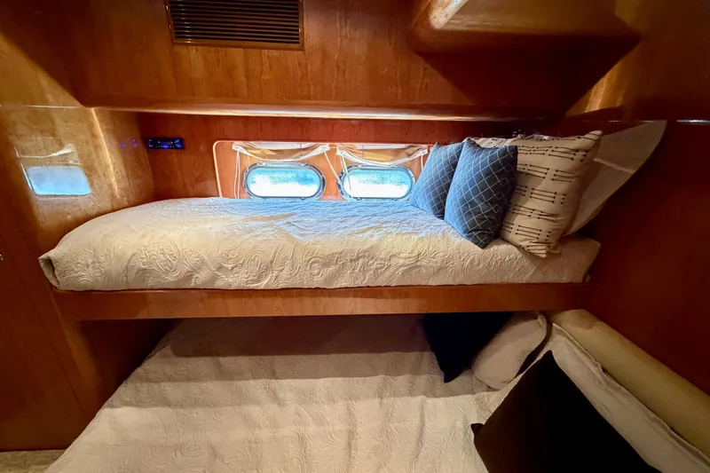 Slide: The Image of Cozy bunk beds in a Horizon 92 yacht cabin with decorative pillows and porthole windows. - 98