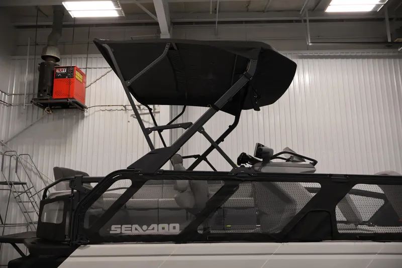 Slide: The Image of 2023 Sea-Doo Switch Sport 21 with canopy in a warehouse setting. - 24