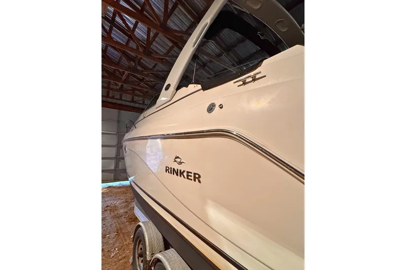 Slide: The Image of 2007 Rinker 270 Express Cruiser in storage, side view showing sleek design. - 3